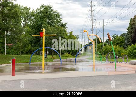 Spielplatz im öffentlichen Park im Sommer ohne Menschen. Brunnen mit Spritzwasser Stockfoto