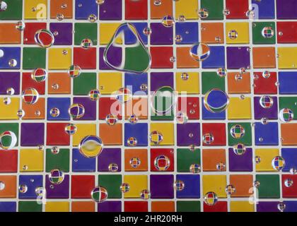 Wassertropfen auf mehrfarbigem Hintergrund Stockfoto