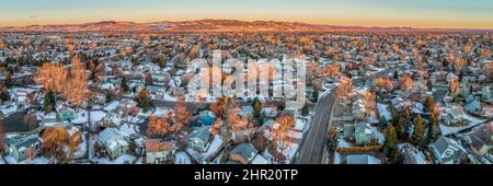 Wintersonnenaufgang über dem Wohngebiet von Fort Collins und den Ausläufern der Rocky Mountains im Norden Colorados mit etwas Schnee und einem Panoramablick aus der Luft Stockfoto