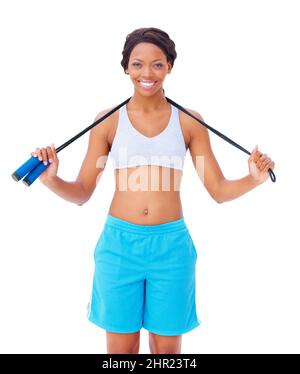 Überspringen bietet große Herz. Eine hübsche junge afroamerikanische Frau, die vor weißem Hintergrund ein Springseil um den Hals hält. Stockfoto