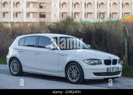 Side, Türkei – Februar 02 2022: An einem warmen Herbsttag steht der weiße BMW 1 vor dem Hintergrund einer Straße auf der Straße Stockfoto