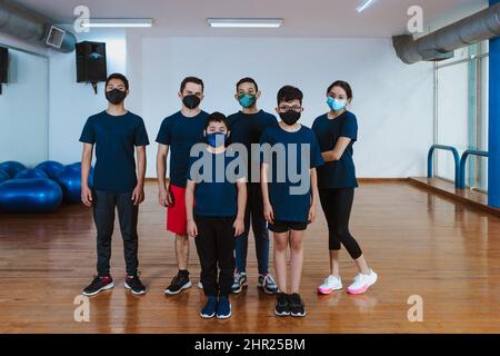 Lateinamerikanische Teenager und hispanische Kinder mit einem Ausbilder mit Gesichtsmaske für eine Coronavirus-Pandemie in einem Sportunterricht in Mexiko, Lateinamerika Stockfoto