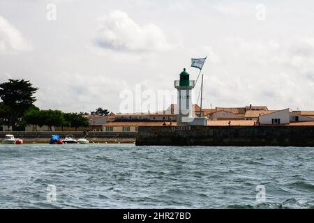 Blick auf den Leuchtturm Phare de la Flotte und einige Boote von einem Boot auf dem Meer auf der Insel ile de Ré in Frankreich im Sommer Stockfoto