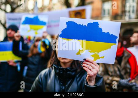 Ein Protestler hält ein Plakat mit einer Karte der Ukraine, die in ukrainischen natonialen Farben - blau und gelb - gemalt ist. Nach dem Beginn der russischen Inv Stockfoto