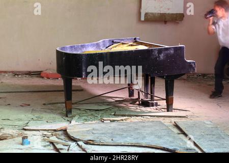 Die Ukraine, in der eingeschränkten und unbewohnbaren 30 Kilometer langen Zone um das Tschernobyl-Kraftwerk und das Pripyat-Arbeitslager, Klavier auf der Bühne des Stockfoto