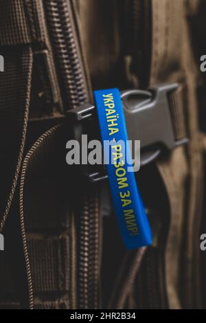 Gelb-blaues Armband mit einer Inschrift auf Ukrainisch: 'Ukraine - gemeinsam für den Frieden!' Verhinderung von Feindseligkeiten in der Ukraine. Friedenskonzept Stockfoto