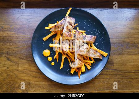 Frisch gekochtes Schweinefleisch Secreto iberico mit Bratkartoffeln und Gaucho-Sauce Stockfoto