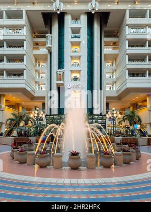 Orlando, Florida - 9. Februar 2022: Vertikale Ansicht der Haupthalle des Terminals B im Inneren des internationalen Flughafens von Orlando (MCO) mit Brunnen im Vordergrund und Stockfoto