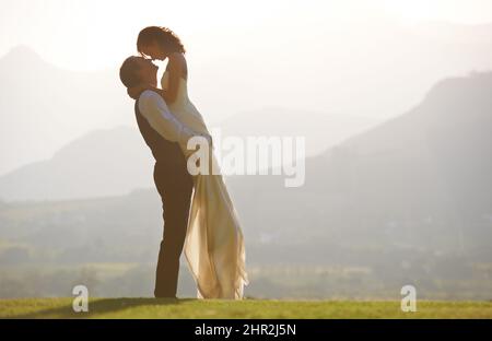 Szenische Hochzeit. Ein Bräutigam hebt seine Braut in die Luft. Stockfoto