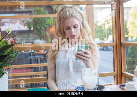 Frau mit Smartphone im café Stockfoto