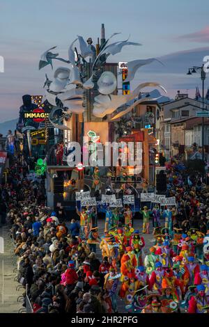 Viareggio, Italien. 24.. Februar 2022. Karneval von Viareggio bei Nacht.der zweite Maskenkurs findet nachts statt und die allegorischen Wagen sind mit neuem Licht gefärbt.Allegorischer Wagen der ersten Kategorie: ''und dann gingen wir hinaus und sahen die Sterne wieder''', Hersteller Cinquini-Brüder.Demonstranten mit Plakaten gegen den Krieg in der Ukraine. (Bild: © Federico Neri/Pacific Press via ZUMA Press Wire) Stockfoto