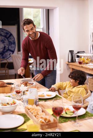 Lasst uns stecken bleiben. Ein Vater und ein Sohn genießen ein Familienessen. Stockfoto