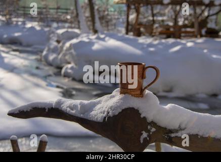 Birkenrindenbecher auf dem Hintergrund einer sonnigen Winterlandschaft. Geschirr aus umweltfreundlichen Materialien. Stockfoto