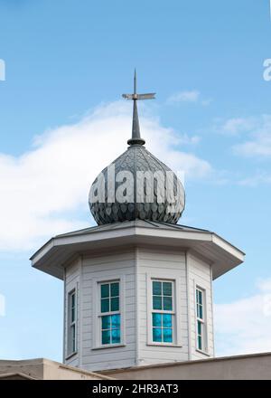 Alte weiße Kirche mit tollen blauen Fenstern. Goldene Motive und Säulen. Die Kirche ist ein Wahrzeichen der Stadt. Stockfoto