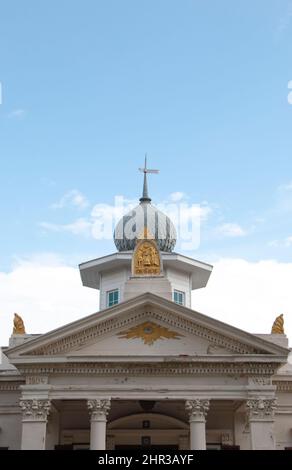 Alte weiße Kirche mit tollen blauen Fenstern. Goldene Motive und Säulen. Die Kirche ist ein Wahrzeichen der Stadt. Stockfoto