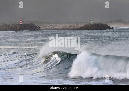 Steinpier mit Leuchttürmen, große Wellen krachen an der Küste von Nazare in Portugal. Stockfoto