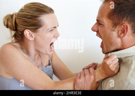 ID lieber geliebt und verloren haben. Nahaufnahme einer Frau, die sich vor Wut das Hemd ihres Mannes schnappt, während sie kämpfen. Stockfoto