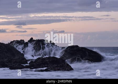 Vulkanische Felsen in der Dämmerung, Playa El Bollullo Strand in der Nähe von Puerto de la Cruz an der Nordküste von Teneriffa Kanarische Inseln Spanien. Stockfoto