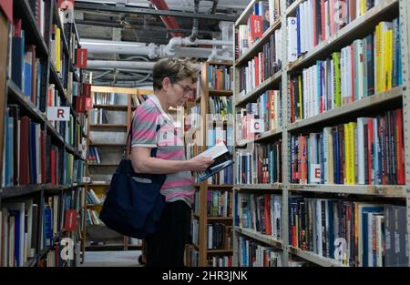 Eine Frau kauft im Strand Bookstore am Broadway in Greenwich Village, Manhattan, für gebrauchte Bücher aus der Politikwissenschaft ein. Stockfoto