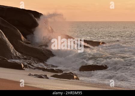 In der Dämmerung plätschern Wellen auf Felsen, der Strand Praia Cabedelo do Douro in Porto Portugal. Stockfoto