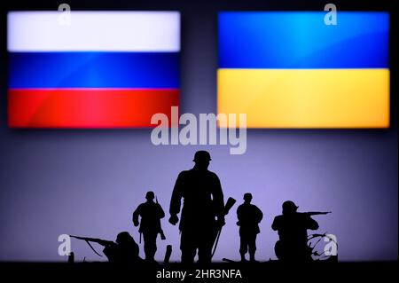 Krieg in der Ukraine. Russland greift die Ukraine an. Illustration Foto. Silhouette der Soldaten, Nationalflagge im Hintergrund. Konflikt in Europa Stockfoto