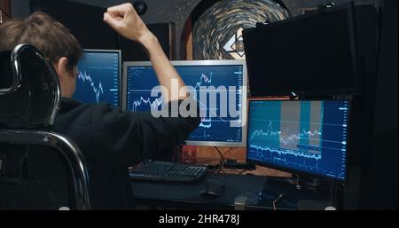 Trader an der Börse, sieht Wachstum der Notierungen auf dem Chart und ist sehr glücklich Stockfoto