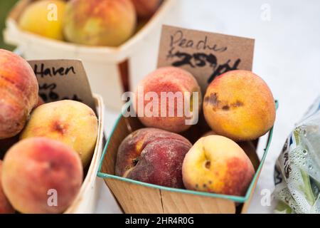 Nahaufnahme von reifen Pfirsichen in einer Schachtel, die im Laden angezeigt wird Stockfoto