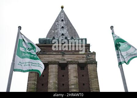 Kiel, Deutschland. 25.. Februar 2022. Vor dem Kieler Rathaus fliegen Flaggen mit der Aufschrift "Bürgermeister für den Frieden". Als Zeichen für den Frieden wird die Landeshauptstadt am Freitag, den 25. Februar und Samstag, den 26. Februar, die Flagge des internationalen Bündnisses Mayors for Peace im Rathaus aufführen. Quelle: Axel Heimken/dpa/Alamy Live News Stockfoto