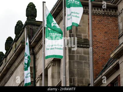 Kiel, Deutschland. 25.. Februar 2022. Vor dem Kieler Rathaus fliegen Flaggen mit der Aufschrift "Bürgermeister für den Frieden". Als Zeichen für den Frieden wird die Landeshauptstadt am Freitag, den 25. Februar und Samstag, den 26. Februar, die Flagge des internationalen Bündnisses Mayors for Peace im Rathaus aufführen. Quelle: Axel Heimken/dpa/Alamy Live News Stockfoto