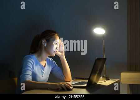 Asiatische Frau arbeiten spät in der Nacht stressig mit Projektforschungsproblemen auf einem Laptop-Computer oder Notebook zu Hause Büro Burnout-Syndrom Konzept. Stockfoto