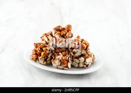 Brondong Jagd oder Bororndong, javanesischer traditioneller Snack Süßer Popcorn mit klebriger Palmzucker. Auf Weißem Teller Stockfoto