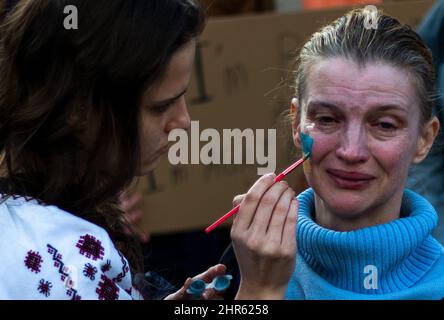 Sacramento, USA. 24.. Februar 2022. Am Donnerstag, den 24. Februar 2022, wird Gesichtsfarbe auf ein Mitglied der slawischen Gemeinde aufgetragen, während es gegen die russische Invasion in der Ukraine im kalifornischen Kapitol in Sacramento, Kalifornien, protestierte. (Foto von Rahul Lal/Sipa USA) Quelle: SIPA USA/Alamy Live News Stockfoto