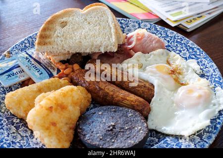Ein großes Wetherspoons Frühstück wird in einem Wetherspoons Pub serviert. Das Frühstück ist 1406 Kalorien. Der zusätzliche Blutwurst fügt zusätzliche 352 Kalorien hinzu Stockfoto