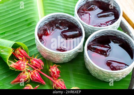 Roselle Saft im Glas auf Banana leaf Hintergrund für Trinken Sommer Tag Stockfoto