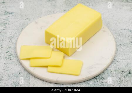 Kashar-Käse oder Kashkaval-Käse auf steinernem Hintergrund. Cheddar-Käse In Scheiben Stockfoto