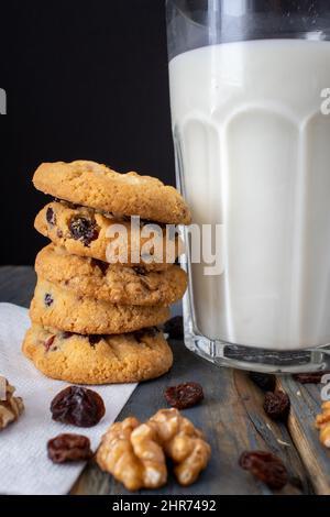 Leckere Kekse mit Schokolade und frischer Milch in einem Glas auf einem hellen Tisch. Eine Idee für ein Kinderfrühstück oder einen Snack. Selektiver Fokus Stockfoto