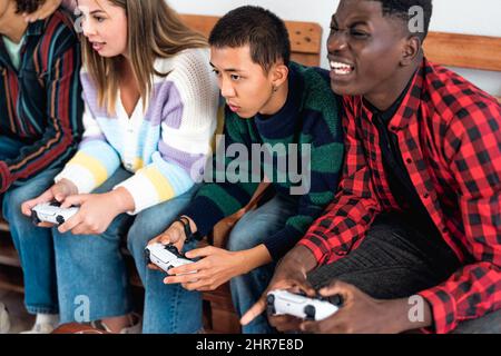 Junge multirassische Jugendliche spielen online Videospielkonsole zu Hause - Jugendliche süchtig nach neuer Technologie Gaming-Unterhaltung Stockfoto