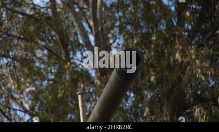 Bild eines Kanons eines Panzers, der in einem Krieg verwendet wurde, der in den Lauf der Kanone blickt. Nahaufnahme eines rostigen Militärpanzers, Panzerkanon. Stockfoto