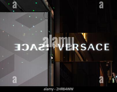 Zürich, Schweiz - 30. Dezember 2021: Versace-Zeichen mit Spiegelung im Fenster. Versace ist ein italienisches Modelabel. Stockfoto