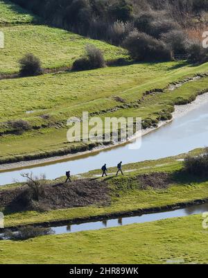 Brighton UK 25. February 2022 - Walkers by the River Cuckmere and Valley near Alfriston , Sussex an einem schönen sonnigen Tag mit einer eher ruhigen Wettervorhersage für die nächsten Tage : Credit Simon Dack / Alamy Live News Stockfoto