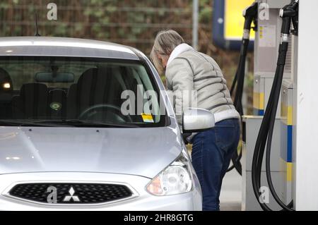 Frankfurt, Deutschland. 25.. Februar 2022. Eine Frau füllt einen Tank an einer Tankstelle in Frankfurt, Deutschland, 25. Februar 2022. Aufgrund der Befürchtungen, dass die Versorgung aufgrund der Besorgnis über die eskalierenden Spannungen zwischen Russland und der Ukraine unterbrochen werden könnte, stiegen die Rohöl- und Erdgaspreise auf mehrjährige Höchststände und es wurde erwartet, dass sie sich platetieren, wenn nicht sogar weiter steigen würden. Die Spitzen untermauerten die Aussichten für eine höhere Inflation, die bereits vielen Haushalten einen Schlag versetzt hatte, während Ökonomen sagten, dass es den Zentralbanken schwer fallen würde, sie einzudämmen. Quelle: Armando Babani/Xinhua/Alamy Live News Stockfoto