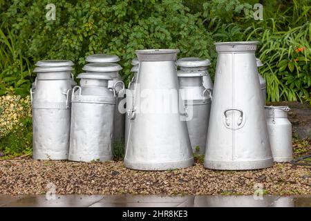 Eine Gruppe von Stahlmilchbücken auf dem Bahnhofssteig Stockfoto