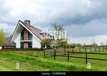 Blauwestad, Niederlande - 1. Mai 2021: Schönes modernes Haus mit Reetdach in der neu entwickelten Stadt Blauwestad in Oldambt Groningen in den Niederlanden Stockfoto