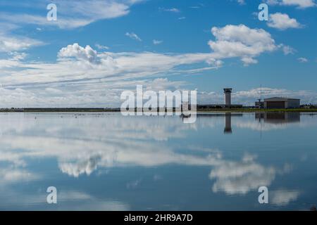 Der Kontrollturm des Internationalen Flughafens Larnaca spiegelt sich am 25. Februar 2022 im Salzsee Larnaca, Zypern, wider. Aufgrund der russischen Invasion in der Ukraine wurden unter anderem alle Flüge von Kiew nach Larnaka gestrichen. (Foto von Kostas Pikoulas/Sipa USA) Stockfoto