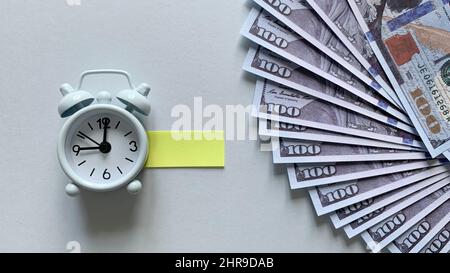 Draufsicht auf Wecker und Banknoten auf weißem Hintergrund. Konzept für den Kopierraum Stockfoto