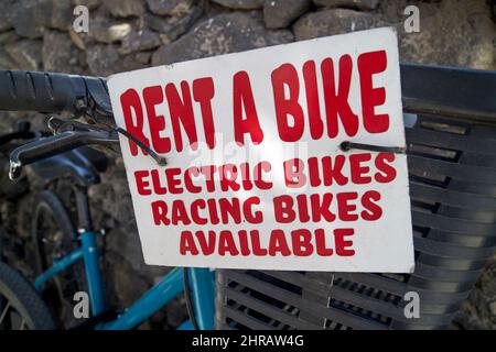 Mieten Sie sich ein Fahrradschild mit Elektro- und Rennrädern auf Lanzarote, Kanarische Inseln, Spanien Stockfoto