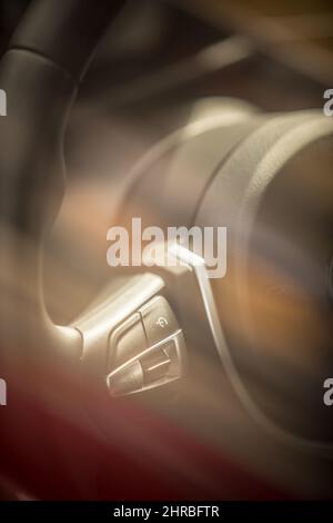 Farbdetail der Tempomat-Tasten am modernen Auto-Lenkrad. Stockfoto
