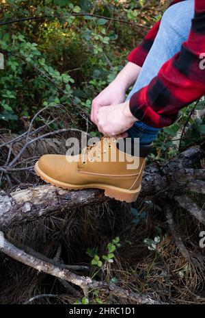 Nahaufnahme eines Mannes, der im Wald, Spanien, Schnürsenkel auf seinen Wanderschuhen bindet Stockfoto