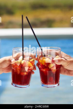 Heres bis zum Sommer. Nahaufnahme von zwei Freunden, die sich mit ihrer Brille gegenseitig toasten. Stockfoto