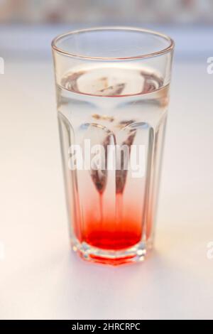Eistee-Beutel in Glas mit klarem Wasser Stockfoto